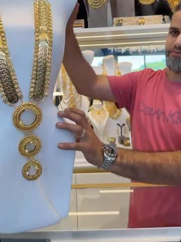 A heavy layered gold set with coin pendants held up on a mannequin